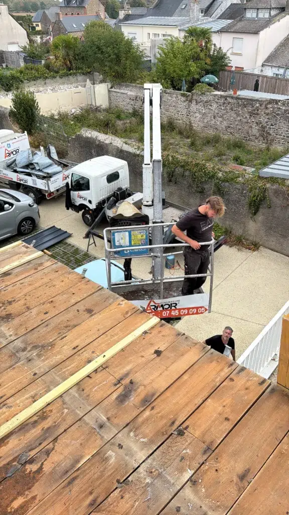 Plan d'ensemble de la Boucherie Doyet à Plourhan sous un ciel gris, avec sa toiture en zinc d'origine avant le chantier de remplacement par Armor Couverture 22.