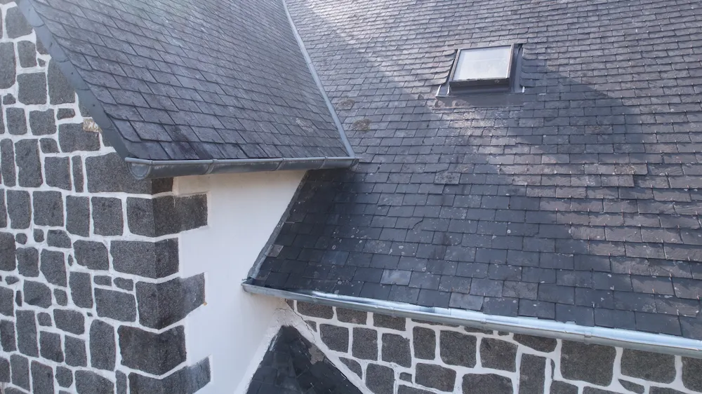 Vue d'ensemble de la toiture avec sa nouvelle gouttière parfaitement installée et raccordée par Armor Couverture 22 à Saint-Brieuc.