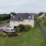 Nettoyage en cours d'une couverture en ardoises avec élimination des lichens par un couvreur à Langueux.