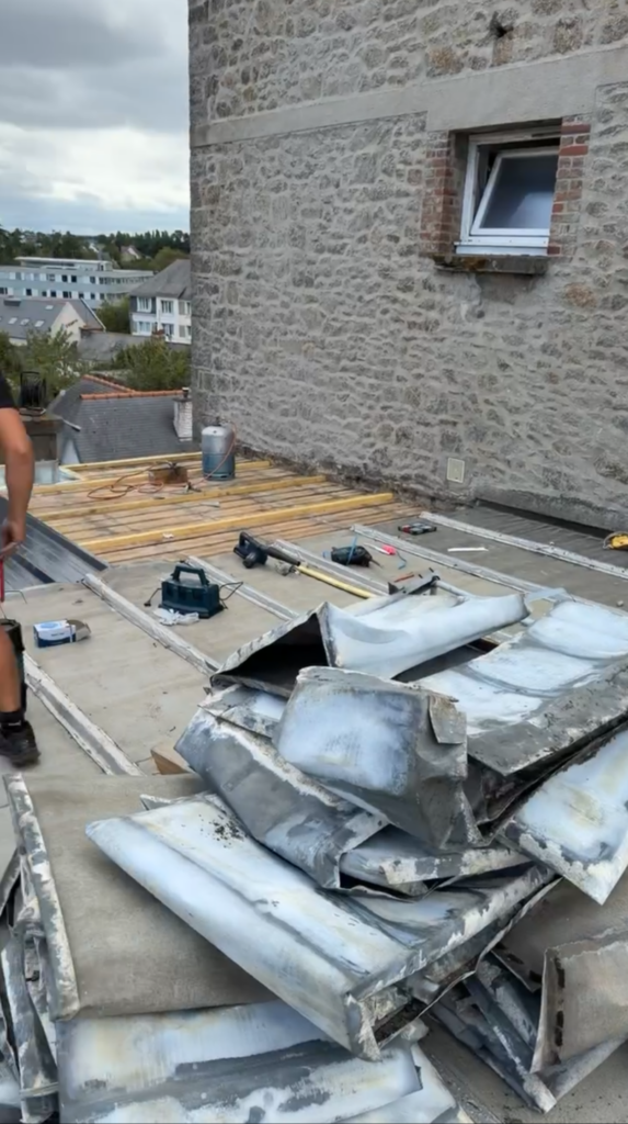 Dépose d'une ancienne couverture en zinc sur une toiture à Saint-Brieuc.