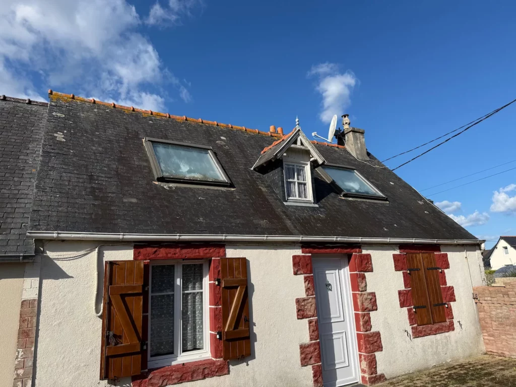 Toiture ancienne en ardoise naturelle dégradée et couverte de mousse sur une maison traditionnelle en Bretagne avant rénovation par Armor Couverture 22.